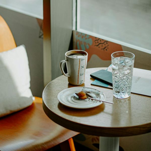 Glass of water on a wooden table next to yoga blocks